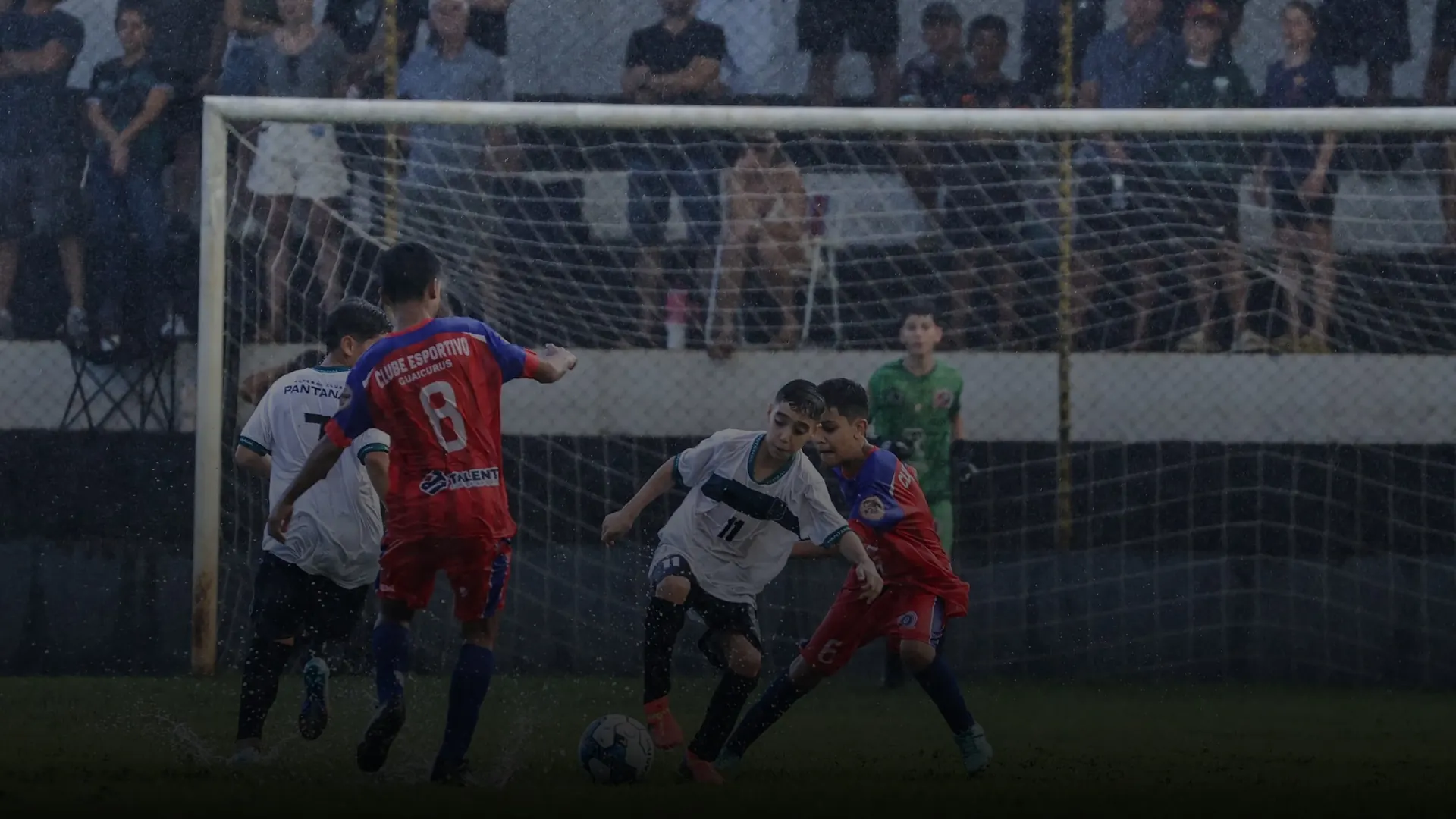 Jogo do Pantanal com torcida na arquibancada, sob chuva